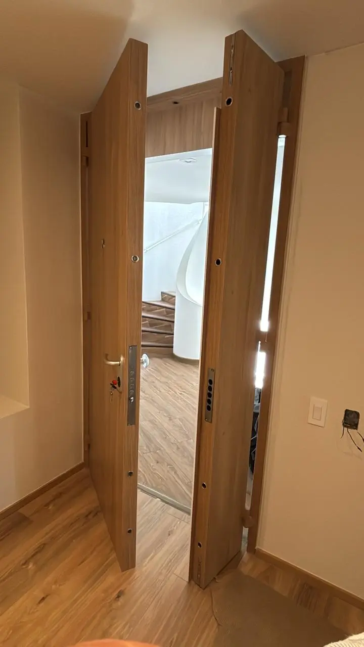 Puerta de seguridad en madera tono roble con diseño elegante.