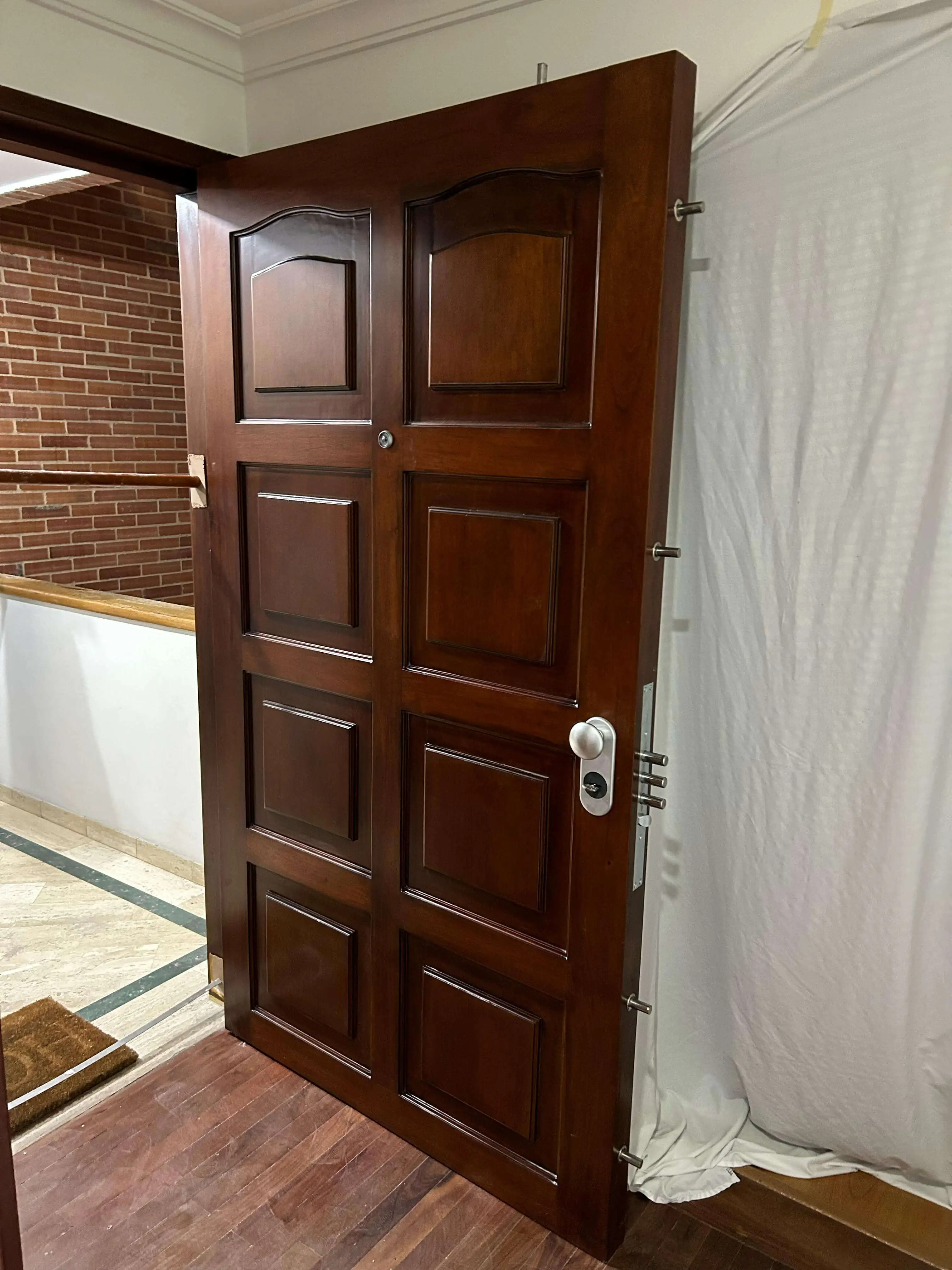 Puerta de seguridad en madera instalada con acabado final en Bogotá.